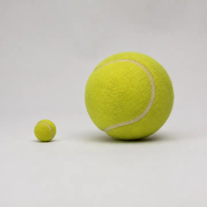 Two yellow tennis balls on a white background: a small one on the left and a much bigger one on the right.
