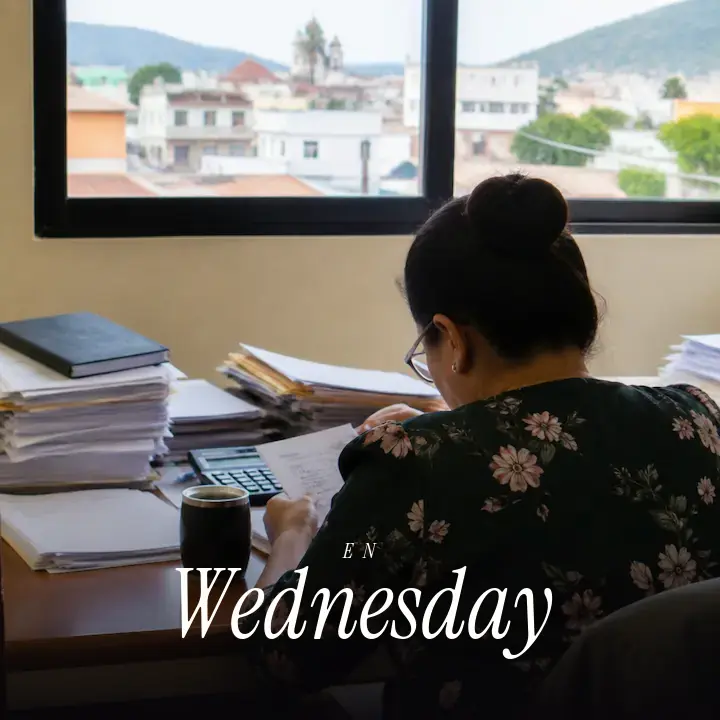 A busy office desk seen over someone's shoulder, with papers and a half-finished cup, and the English word Wednesday printed across the bottom.